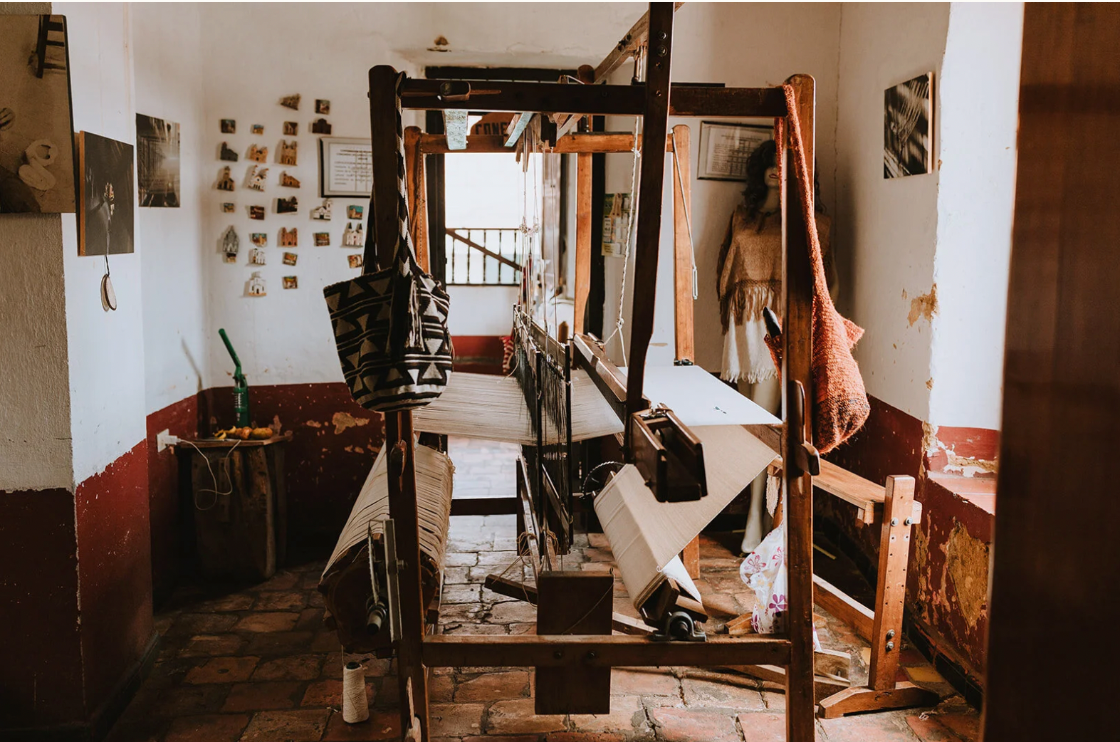 Vintage loom in a room with wooden floor and white walls. Equipment used by our artisans in Colombia