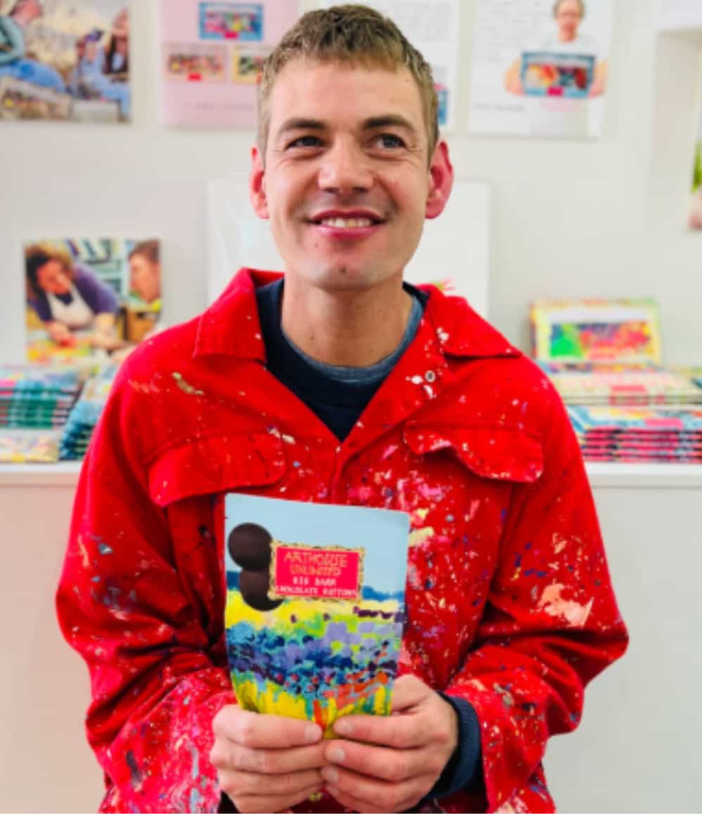 ARTHOUSE Unlimited artist holding a Sea of Daffodils dark chocolate buttons bag
