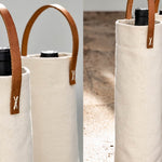 Natural canvas wine carriers with leather handles holding wine bottles