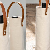 Natural canvas wine carriers with leather handles holding wine bottles