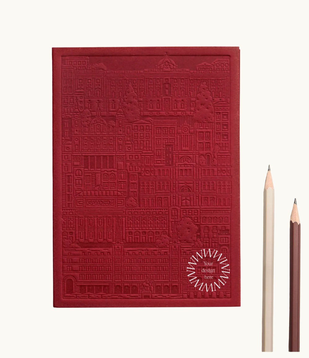 Red notebook with embossed design of the city of Madrid. Personalised corporate gift from women-owned brands