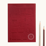 Red notebook with embossed design of the city of Madrid. Personalised corporate gift from women-owned brands