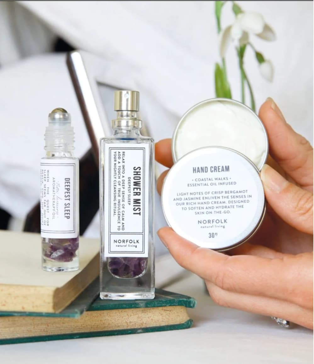 Deepest Sleep pulse point oil, shower mist and hand cream displayed in a wellbeing setting.