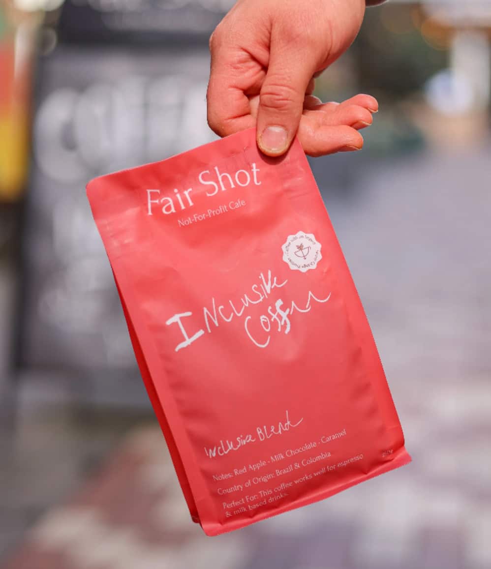 Fair Shot Inclusive Blend coffee bag held by hand
