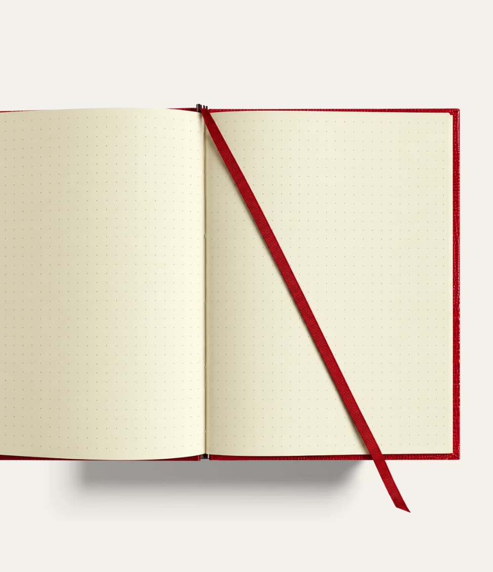 Open A5 travel notebook with cream dot grid pages, gold-gilded edges and ribbon bookmark. Personalised corporate gift for executives, clients and conferences, handmade in England.