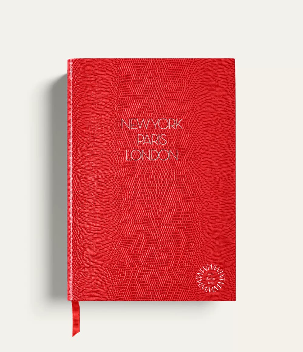 Personalised travel notebook, red A5 hardcover with gold New York Paris London lettering. Sustainable executive corporate gift from women-owned brands, handmade in England.