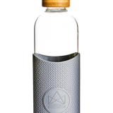 1L reusable glass water bottle with grey silicone sleeve and bamboo lid, premium branded merchandise and practical takeaway swag
