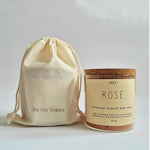 A jar of Vely Rosé botanical mineral bath soak next to a cream-colored drawstring pouch with 'the Vely Soapery' printed on it, set against a plain light gray background.