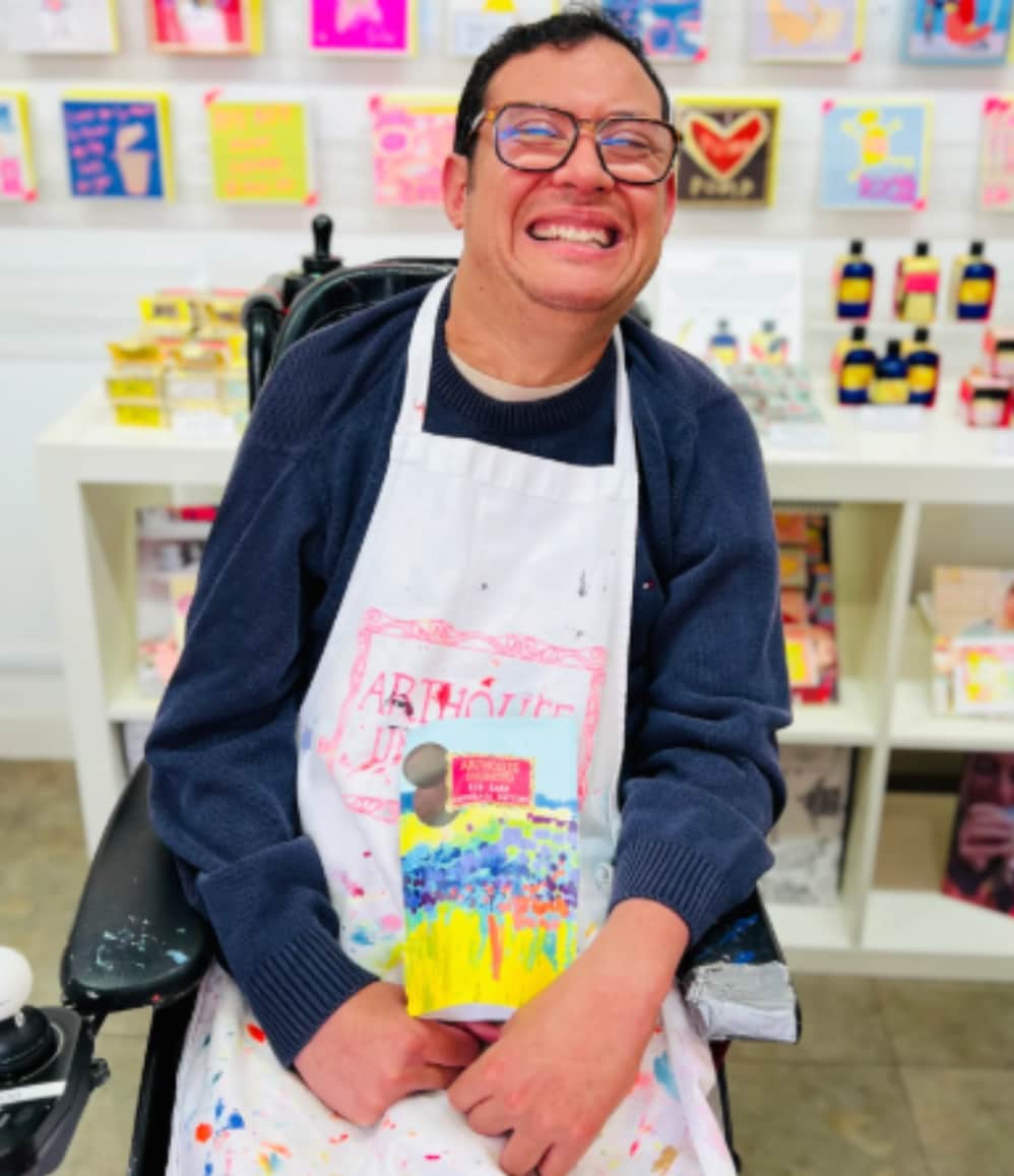 ARTHOUSE Unlimited artist holding the Sea of Daffodils dark chocolate buttons featuring collaborative artwork