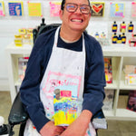 ARTHOUSE Unlimited artist holding the Sea of Daffodils dark chocolate buttons featuring collaborative artwork