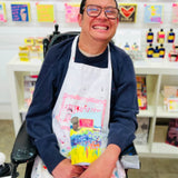 ARTHOUSE Unlimited artist holding the Sea of Daffodils dark chocolate buttons featuring collaborative artwork