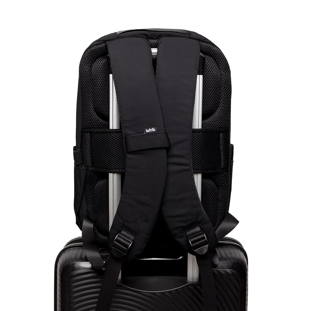 Lightweight Water Resistant Backpack 12L in black, back, showing straps and attached to a carry-on luggage handle