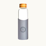 Reusable glass water bottle with grey silicone sleeve and bamboo lid, branded corporate gift for meeting rooms and offsites