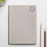 Debossed Barcelona notebook in grey. Branded sustainable notebook from women-owned brands.
