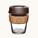 12oz reusable glass cup with a natural cork band, mocha lid, showing logo placement on the cork band
