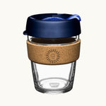 12oz reusable glass cup with a natural cork band, navy lid, showing logo placement on the cork band