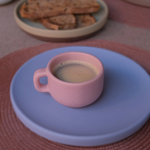 Pink ceramic coffee cup and blue saucer, luxury corporate gifting.