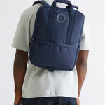 Daily 15" Backpack in blue, worn, showing logo placement