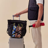 Eco-Friendly Travel Umbrella in magenta, being carried alongside luggage while travelling