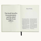 Five Minute Journal Health & Fitness Edition, open to the page "The body benefits from movement and the mind from stillness"
