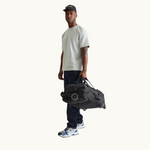 Foldable Travel Bag with Wheels in Black lifestyle view, recycled PET sustainable premium merch, water resistant