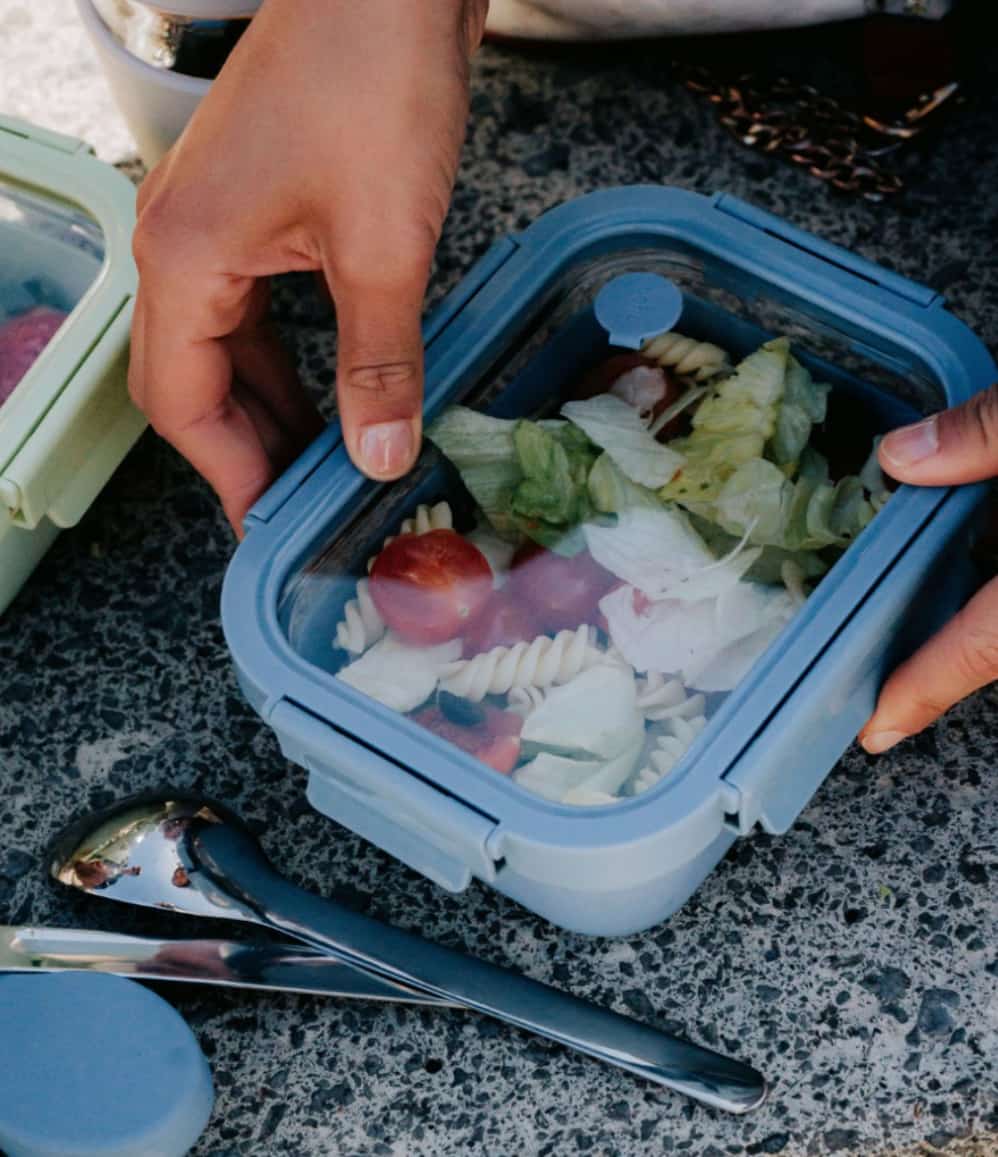 Glass Airtight Lunch Box in blue, held by a woman, showing logo placement