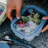 Glass Airtight Lunch Box in blue, held by a woman, showing logo placement