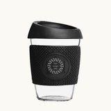 Glass Coffee Cup 12oz in black, with a silicone thermal sleeve, showing logo placement
