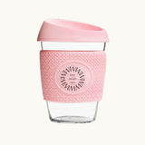 Glass Coffee Cup 12oz in pink, with a silicone thermal sleeve, showing logo placement