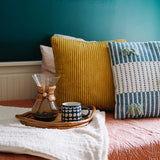 Handwoven organic cotton cushion cover with colourful tassels, for office interiors and event styling.