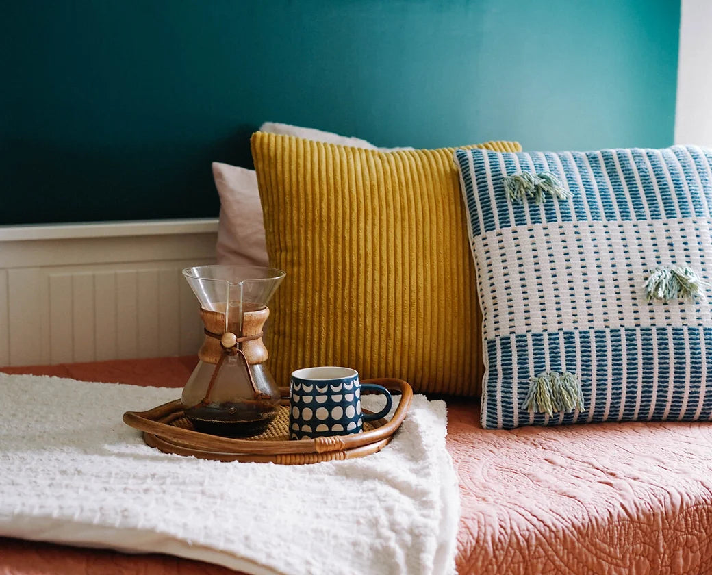 Handwoven organic cotton cushion cover with colourful tassels, for office interiors and event styling.