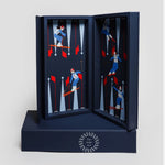 Luxury leather travel backgammon set in Ski Edition, opened to reveal alpine skiing illustrations on navy leather