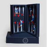 Luxury leather travel backgammon set in Ski Edition, opened to reveal alpine skiing illustrations on navy leather