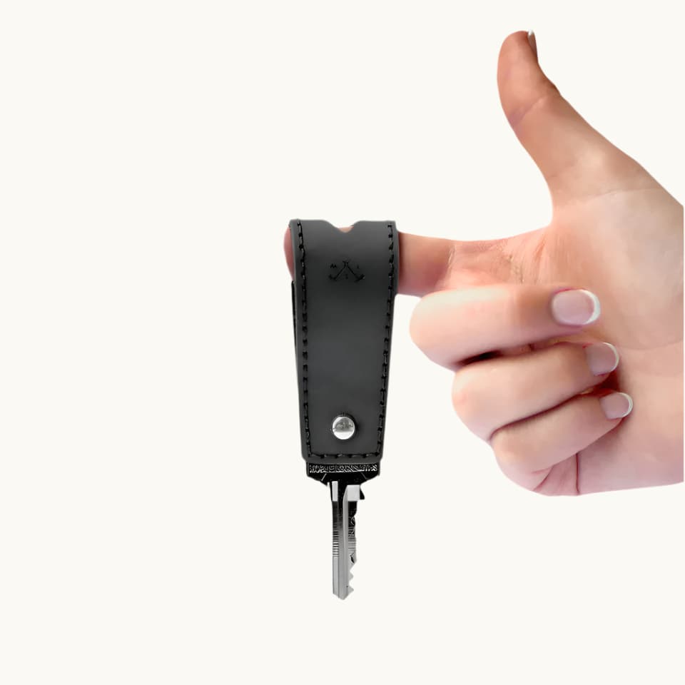 Branded black leather key holder holding five keys, a premium sustainable corporate gift