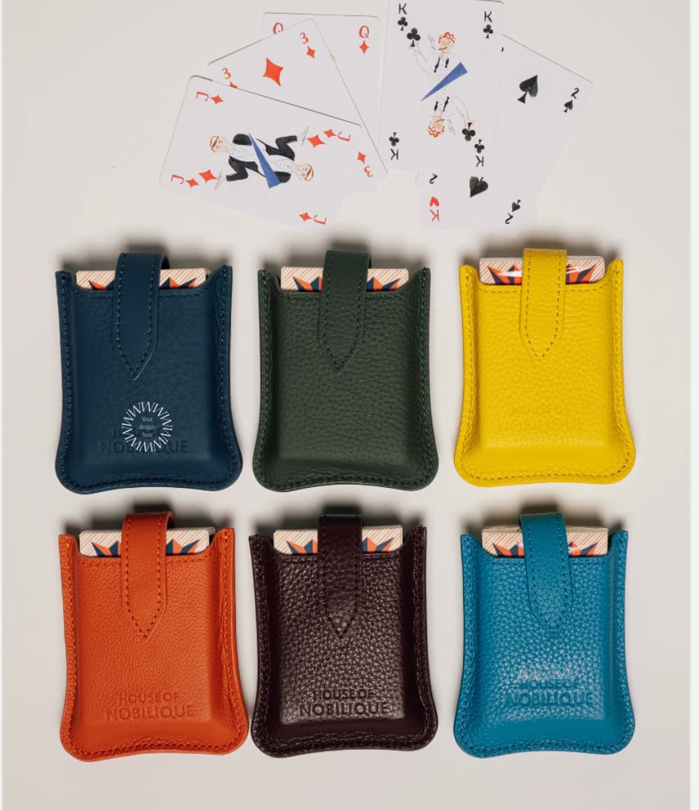 Leather travel playing cards set in yellow, orange, green, blue and burgundy, a sustainable corporate gift for client gifting and employee appreciation.