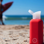 Reusable Glass Bottle 500ml in red, showing logo placement