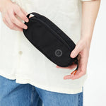 Oval Eco Pencil Case in black, held, showing logo placement