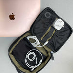 Upcycled travel organiser holding electronics and cables, a sustainable business travel gift.