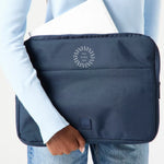 13" Laptop Sleeve in blue, being carried, showing logo placement