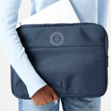 13" Laptop Sleeve in blue, being carried, showing logo placement
