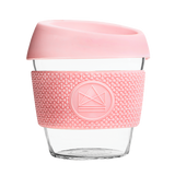 Pink reusable glass coffee cup with thermal sleeve, co-branded for premium merch.