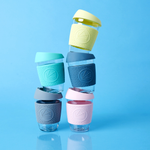 Reusable glass coffee cups in five colours with thermal sleeves, co-branded for premium merch