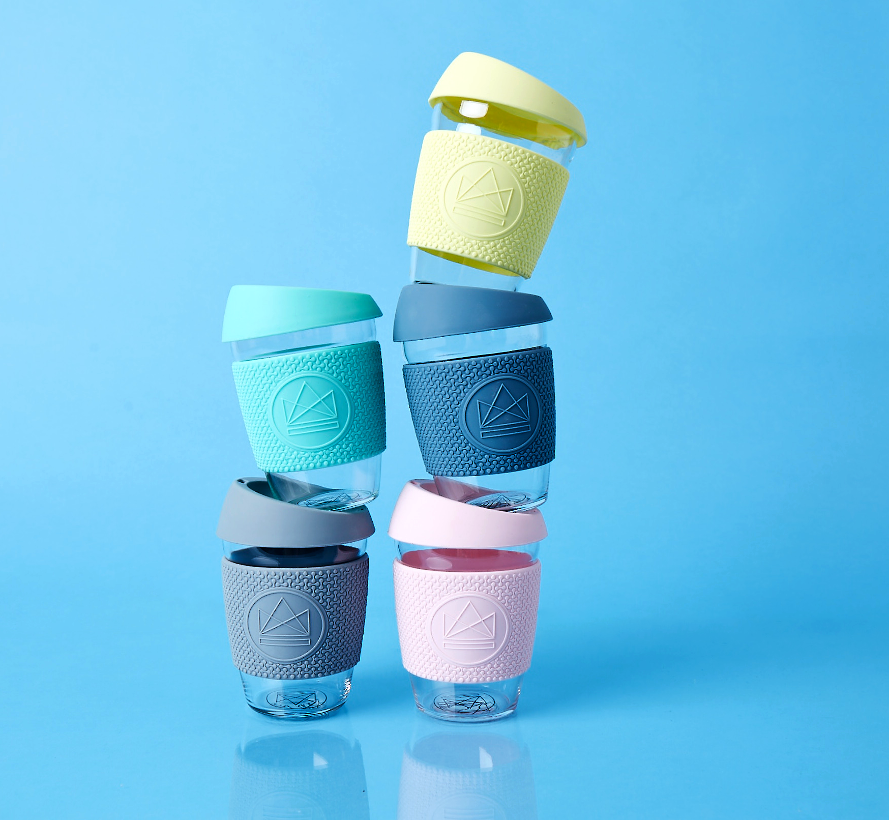 Reusable glass coffee cups in five colours with thermal sleeves, co-branded for premium merch