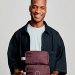 rPET Washbag in maroon, being carried showing logo placement