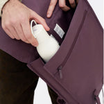 Water Resistant Slim Backpack 12L in maroon, showing the side pocket for a water bottle