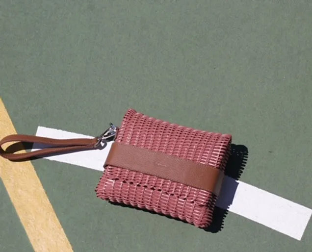 Pink handwoven upcycled belt bag with vegan leather strap and brand tag