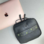 Upcycled travel organiser holding electronics and cables, a business travel gift for executives and conferences.