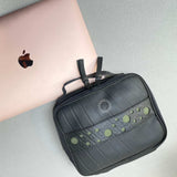 Upcycled travel organiser holding electronics and cables, a business travel gift for executives and conferences.
