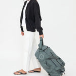 Wheeled Duffel 37L in laurel, being pulled, showing logo placement