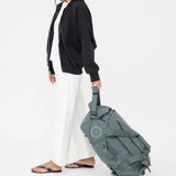 Wheeled Duffel 37L in laurel, being pulled, showing logo placement